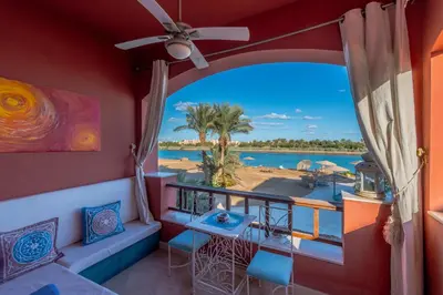 a room with a balcony with a view of the ocean at Special style apartment with pool at lagoon in Hurghada