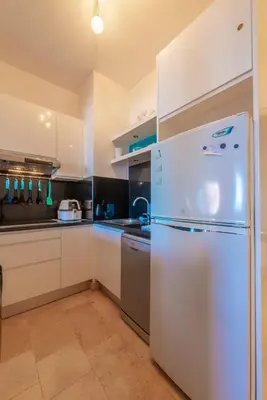 a kitchen with a white refrigerator and a sink at Special style apartment with pool at lagoon in Hurghada