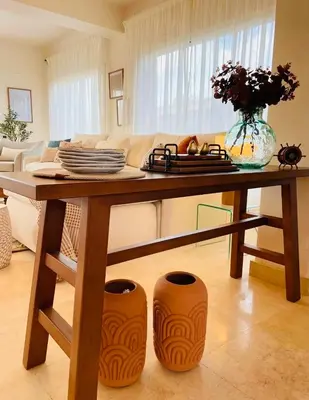 a table with plates and vases on it in a living room at 4BR Villa with Private Pool in Gouna in Hurghada