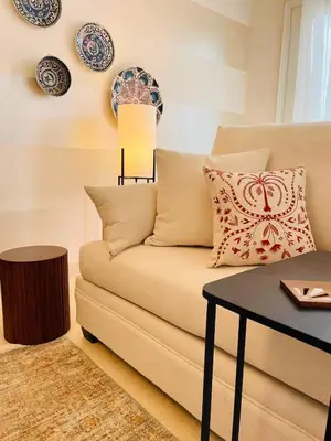 a living room with a couch with a table and plates on the wall at 4BR Villa with Private Pool in Gouna in Hurghada