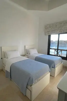 two beds in a white room with a window at 4BR Villa with Private Pool in Gouna in Hurghada