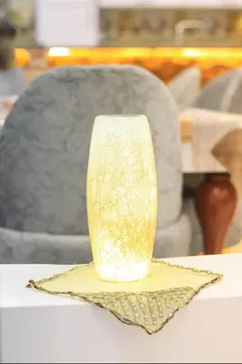 a yellow vase sitting on a napkin on a table at Shahd House in Luxor