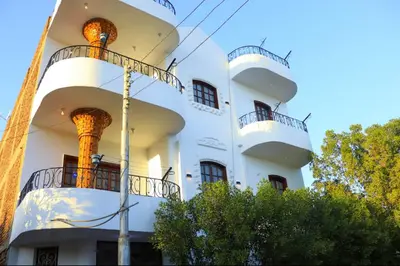 a white building with balconies on the side of it at Shahd House in Luxor