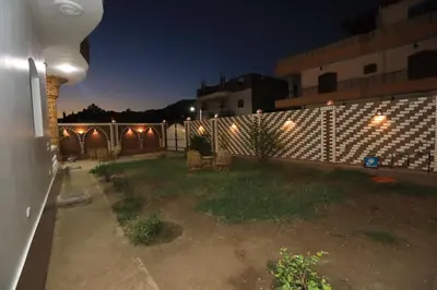 a backyard at night with lights on a fence at Ramsses Palace in Luxor
