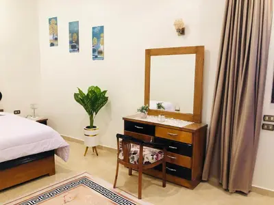 a bedroom with a bed and a dresser with a mirror at joy house in Luxor