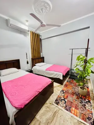 a bedroom with two beds and a ceiling fan at joy house in Luxor