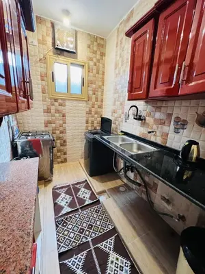 a kitchen with red cabinets and a sink at joy house in Luxor