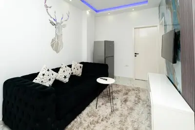 a living room with a black couch and a tv at Hurghada apartment luxury 001 in Hurghada