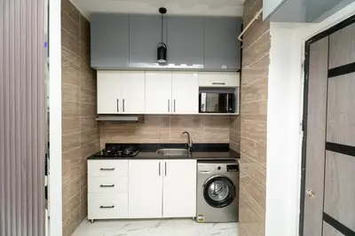 a kitchen with white cabinets and a washing machine at Hurghada apartment luxury 001 in Hurghada