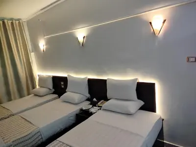 a room with two beds and a couch at Abo Elwafa Hotel in Suwhaj