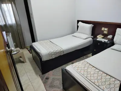 a hotel room with two beds and a window at Abo Elwafa Hotel in Suwhaj