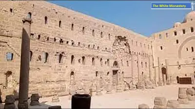 a large brick building with a pillar in front of it at Abo Elwafa Hotel in Suwhaj