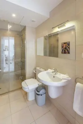 a bathroom with a sink and a toilet and a shower at El Gouna Luxury flat on the pool in El Gouna