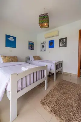 a white bedroom with two beds and a rug at El Gouna Luxury flat on the pool in El Gouna