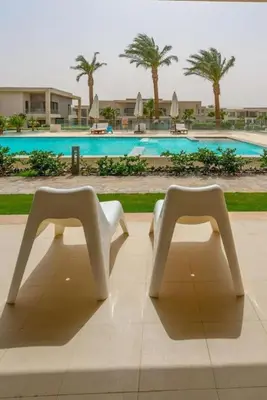 two white chairs sitting in front of a pool at El Gouna Luxury flat on the pool in El Gouna