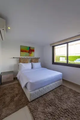 a bedroom with a large white bed with a window at El Gouna Luxury flat on the pool in El Gouna