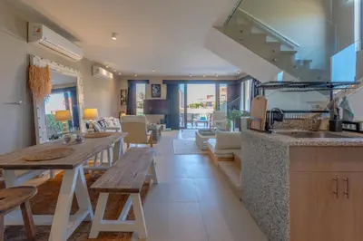 a kitchen and living room with a wooden table at Ultimate Beachstyle Getaway Gouna 2BR Twinhouse. BBQ, Lagoon & Pool Access in Hurghada