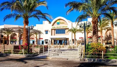 a shopping center with palm trees in front of it at Private 3 bdrm apartment at ElKarma Aqua Beach Reaort in Hurghada