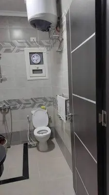 a bathroom with a toilet and a clock on the wall at La Quinta Resort Hurghada in Hurghada