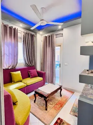 a living room with a purple couch and a table at Luxor apartment in Luxor