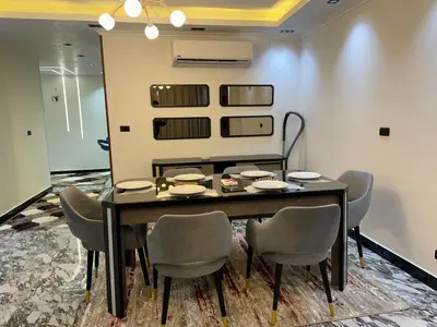 a dining room with a table and chairs at Relaxation, fresh air, and a direct view of the Nile in Naj‘ al ‘Amrāb