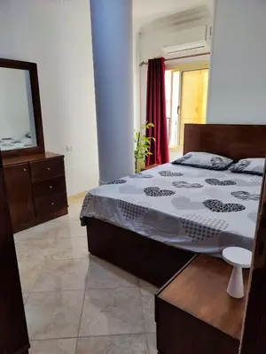 a bedroom with a large bed and a television at Sheraton street METRO in Hurghada