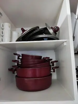 a shelf with plates and pans in a kitchen at Sheraton street METRO in Hurghada