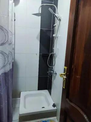 a bathroom with a shower with a sink and a door at Sheraton street METRO in Hurghada