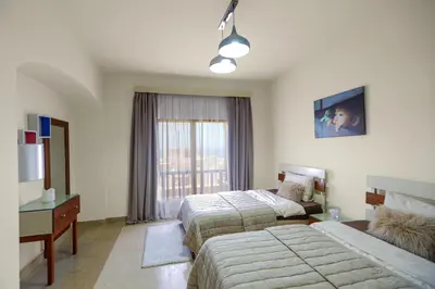 a hotel room with two beds and a window at Azzurra Sahl Haseesh in Hurghada