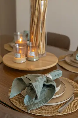 a wooden table with plates and candles on it at Azzurra Sahl Haseesh in Hurghada