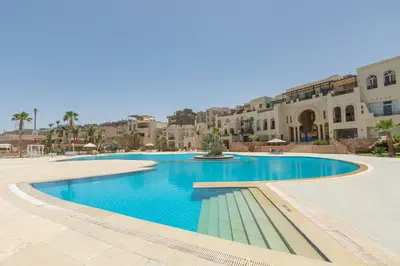 a swimming pool in a resort with buildings in the background at Azzurra Sahl Haseesh in Hurghada