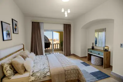 a bedroom with a bed and a desk and a window at Azzurra Sahl Haseesh in Hurghada