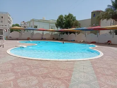 a large swimming pool with blue water in a courtyard at Makramia Compound in Hurghada