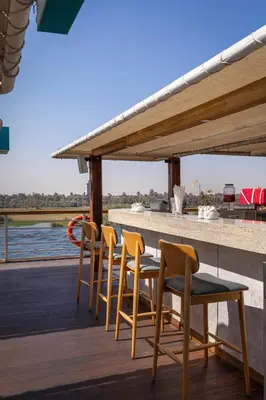 a table and chairs on the deck of a boat at TIA Boutique Nile Cruise - Accommodation Only - Every Monday from Luxor for 04 & 07 Nights - Every Friday From Aswan for 03 & 07 Nights in Luxor