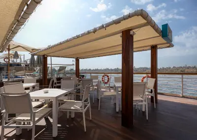 a restaurant with tables and chairs on the deck of a boat at TIA Boutique Nile Cruise - Accommodation Only - Every Monday from Luxor for 04 & 07 Nights - Every Friday From Aswan for 03 & 07 Nights in Luxor