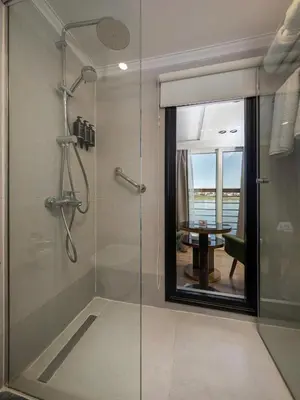 a bathroom with a glass shower with a table at TIA Boutique Nile Cruise - Accommodation Only - Every Monday from Luxor for 04 & 07 Nights - Every Friday From Aswan for 03 & 07 Nights in Luxor