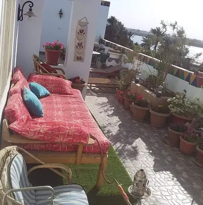 a bed on a patio with potted plants at Abo Hisham Nile Flat in Luxor
