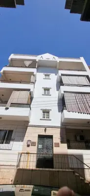 a tall white building with a gate in front of it at Abo Hisham Nile Flat in Luxor