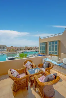 a balcony with wicker chairs and a patio with a view at SeaView Penthouse with Roof in Marina El Gouna Egypt (Center) in Hurghada