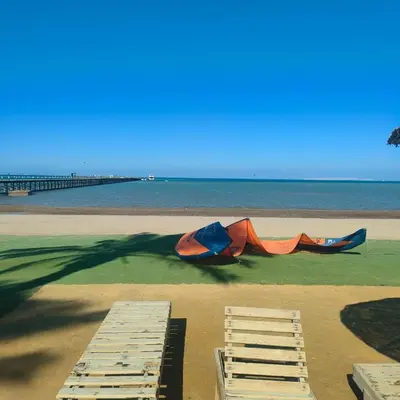 a kite laying on the beach next to two chairs at Hurghada Palma Resort Studio in Hurghada
