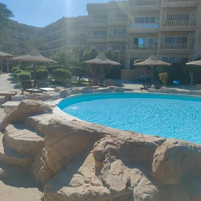 a large swimming pool in a resort with a large building at Hurghada Palma Resort Studio in Hurghada