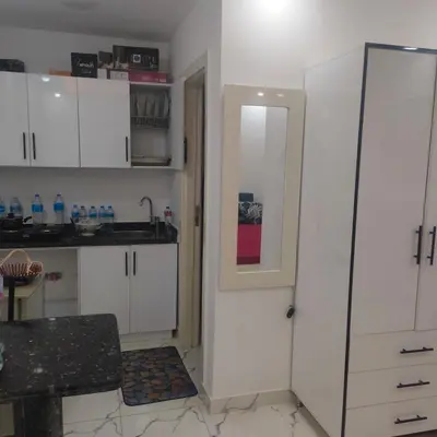 a kitchen with white cabinets and a white door at Hurghada Palma Resort Studio in Hurghada