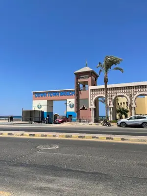 a city street with a building with a palm tree at Villa 2 apartament 3 sea view infront of Palma de Meritee in Hurghada