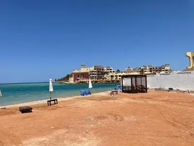a beach with tables and chairs and the ocean at Villa 2 apartment 2 village veiw infront of Palma de Meritee in Hurghada