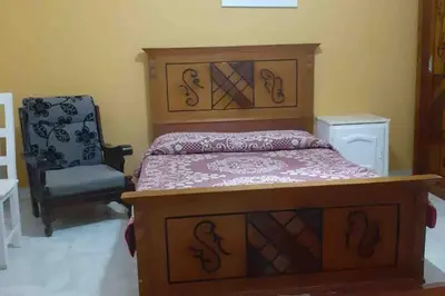 a bedroom with a bed and a chair at Villa 2 apartment 2 village veiw infront of Palma de Meritee in Hurghada