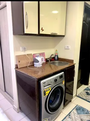 a kitchen with a washing machine and a sink at Studio Pool view with balcony Florenza Hurghada in Hurghada