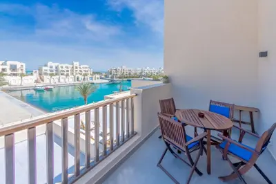 a balcony with a table and chairs and a view of the water at Boutique 2BR in Fanadir Marina - El Gouna. Lagoons & Red Sea in Hurghada