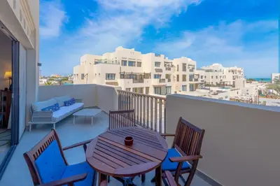 a balcony with a table and chairs and a view of buildings at Boutique 2BR in Fanadir Marina - El Gouna. Lagoons & Red Sea in Hurghada