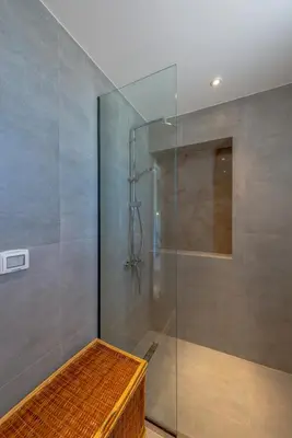 a glass shower with a bench in a bathroom at Boutique 2BR in Fanadir Marina - El Gouna. Lagoons & Red Sea in Hurghada