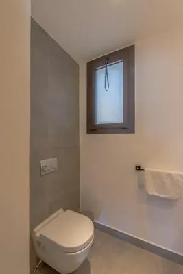 a bathroom with a toilet and a window at Boutique 2BR in Fanadir Marina - El Gouna. Lagoons & Red Sea in Hurghada